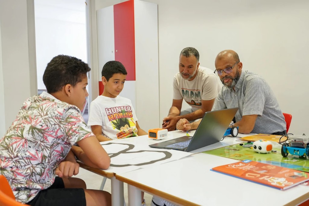 Atelier STEM et robotique : élèves et encadrants autour d'un ordinateur et de robots éducatifs